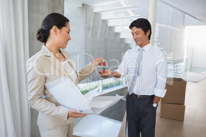 Estate agent giving house key to buyer