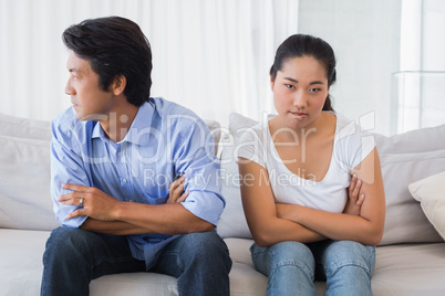 Couple not talking after a dispute on the sofa