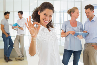 Casual businesswoman giving ok sign to camera