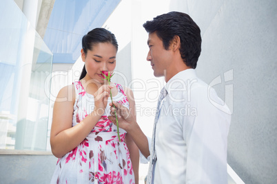 Man offering a red rose to girlfriend