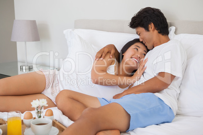 Happy couple having breakfast in bed