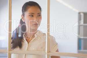 Casual businesswoman looking through window