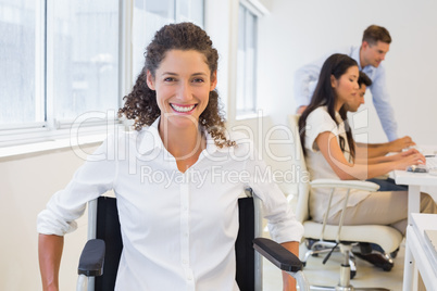 Casual businesswoman in wheelchair smiling at camera