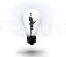 Businesswoman holding tablet in light bulb