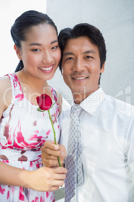 Man offering a red rose to girlfriend