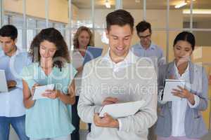 Casual boss standing in front of his team all taking notes