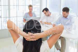 Casual businesswoman leaning back during a meeting