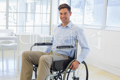 Casual businessman in wheelchair smiling at camera