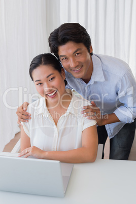 Happy couple using laptop together