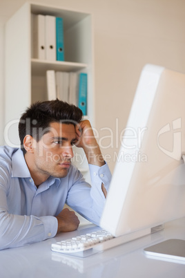 Casual businessman slumped at his desk