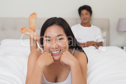 Woman lying on bed smiling at camera