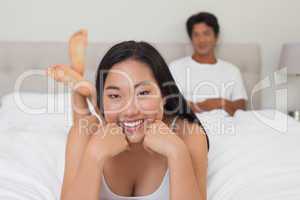 Woman lying on bed smiling at camera