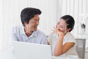 Happy couple using laptop together