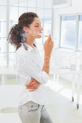 Casual businesswoman smoking an electronic cigarette