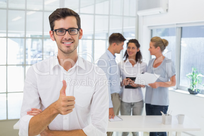 Casual businessman giving thumbs up to camera