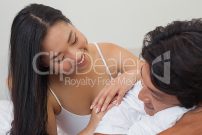 Happy couple lying on bed together