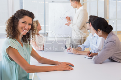 Casual businesswoman smiling at camera during meeting