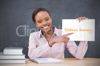 Happy teacher holding page showing distance learning