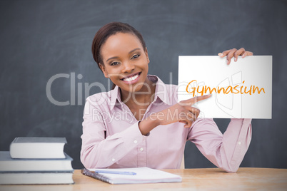 Happy teacher holding page showing gymnasium