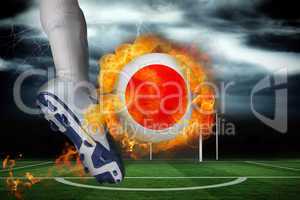 Football player kicking flaming japan flag ball