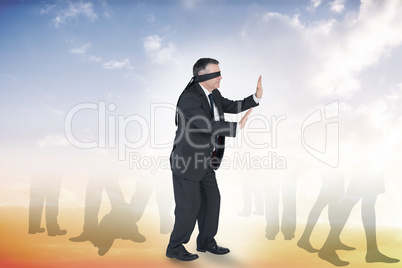 Composite image of mature businessman in a blindfold