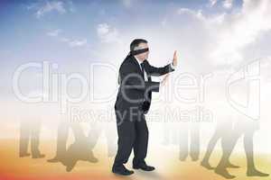 Composite image of mature businessman in a blindfold