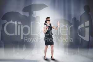 Composite image of redhead businesswoman in a blindfold