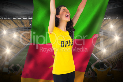 Excited football fan in brasil tshirt holding cameroon flag