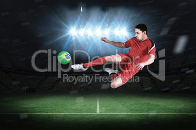 Fit football player jumping and kicking