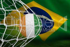 Football in ivory coast colours at back of net