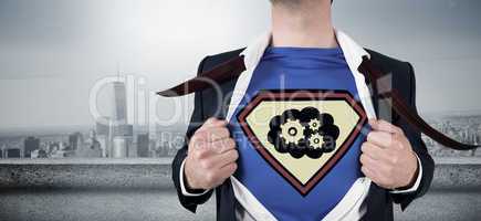Composite image of businessman opening shirt in superhero style