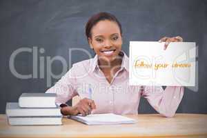 Happy teacher holding page showing follow your dreams