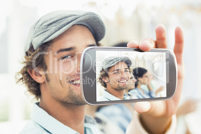 Composite image of hand holding smartphone showing