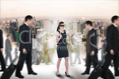 Composite image of redhead businesswoman in a blindfold