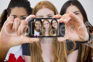 Composite image of hand holding smartphone showing