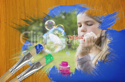 Composite image of little girl blowing bubbles