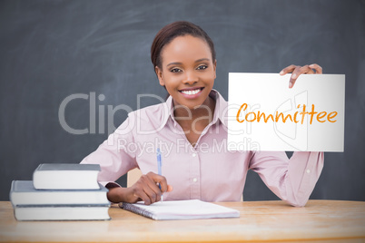 Happy teacher holding page showing committee
