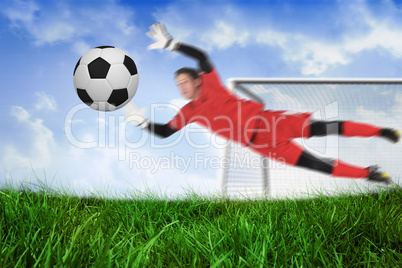 Fit goal keeper jumping up saving ball