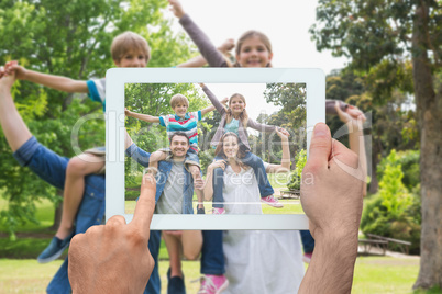 Composite image of hand holding tablet pc