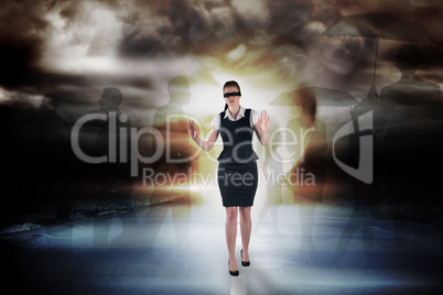 Composite image of redhead businesswoman in a blindfold