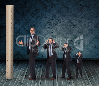 Composite image of multiple image of angry businessman with ruler