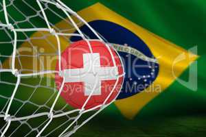 Football in swiss colours at back of net
