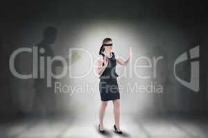 Composite image of redhead businesswoman in a blindfold