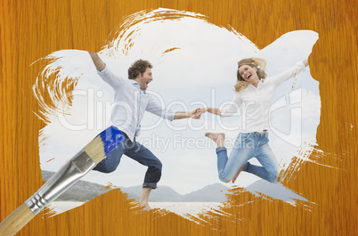 Composite image of couple jumping on the beach