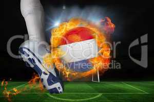 Football player kicking flaming netherlands flag ball