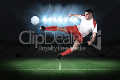 Fit football player playing and kicking