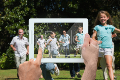 Composite image of hand holding tablet pc