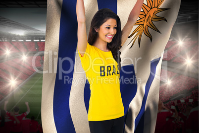 Excited football fan in brasil tshirt holding uruguay flag