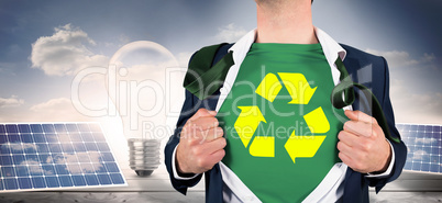 Composite image of businessman opening shirt in superhero style