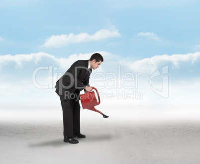 Composite image of businessman watering with red can